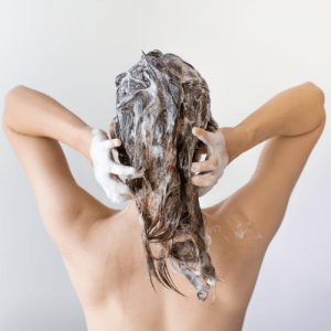 אישה חופפת את השיער